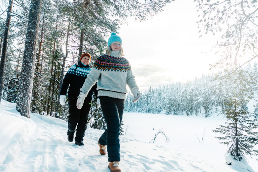 Hiking in snowy forest at Arctic Lakeland